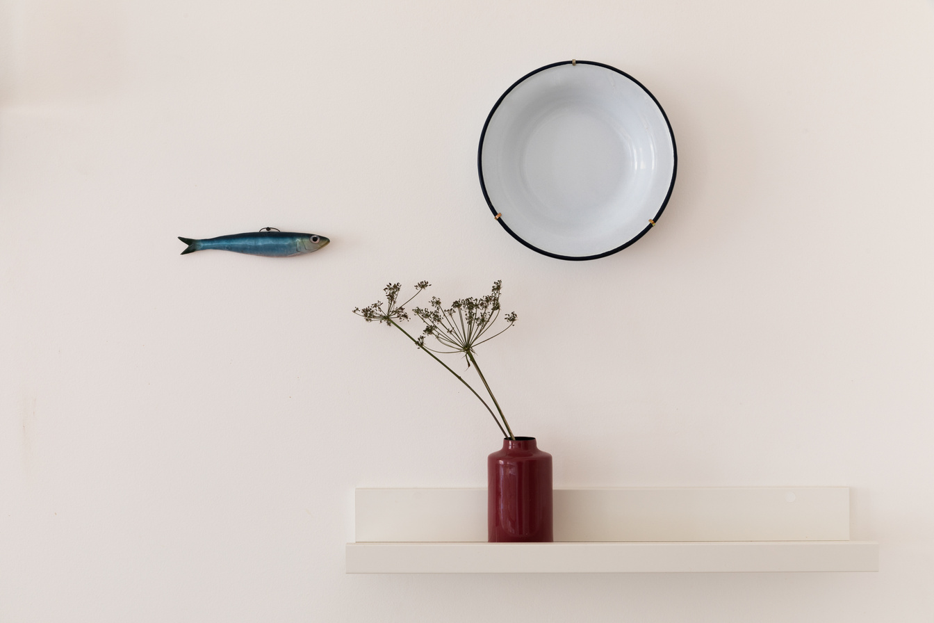 Minimal wall styling with a clay vase and organic branches